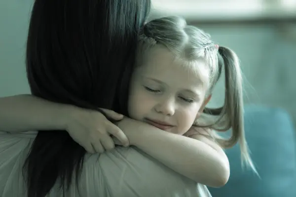 A parent sitting with their child, offering calm and compassionate support during a difficult emotional moment.